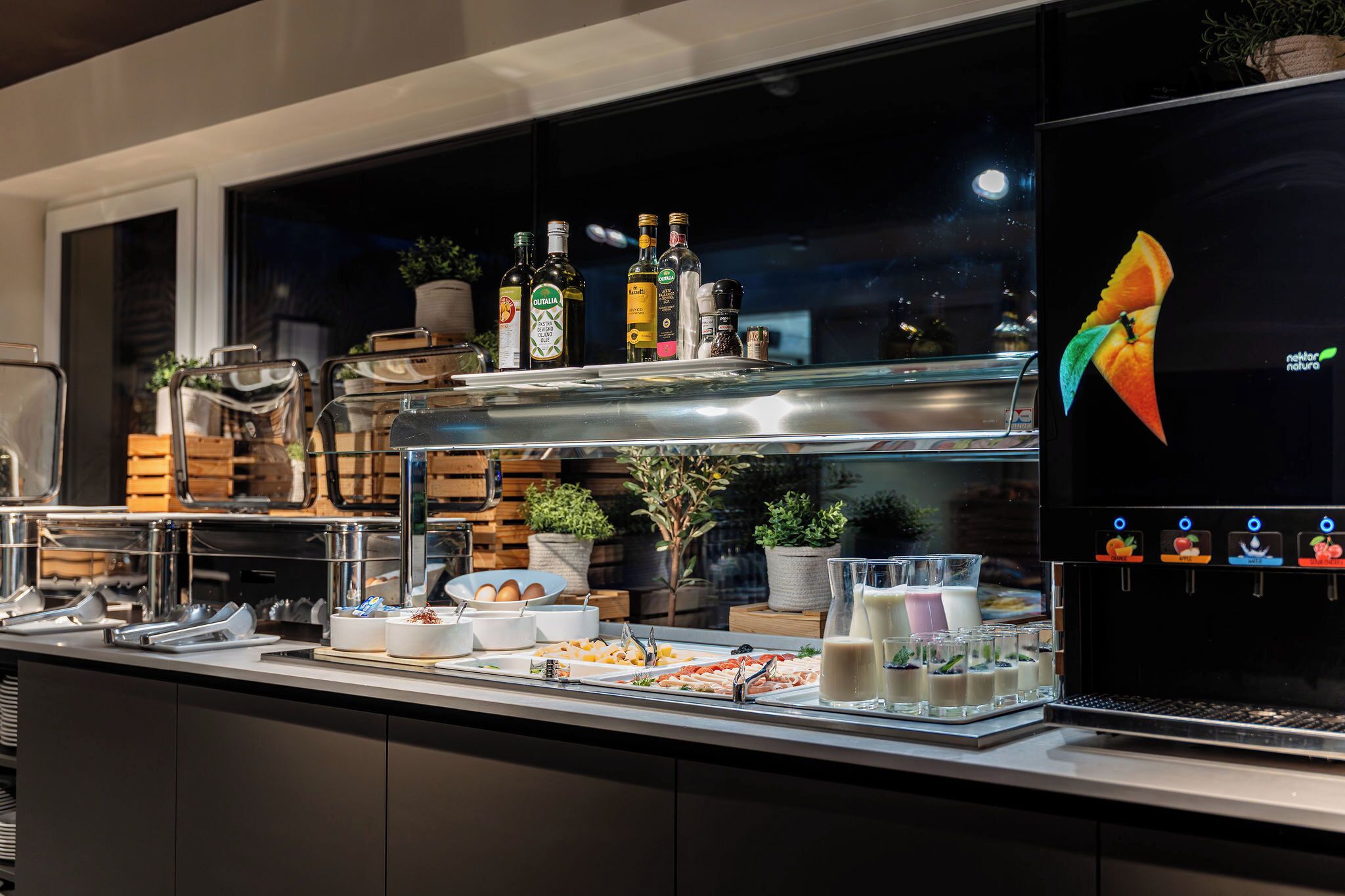 A buffet area with various food items, beverages, and a coffee machine.