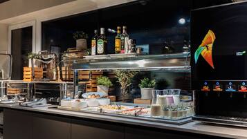 A buffet area with various food items, beverages, and a coffee machine.