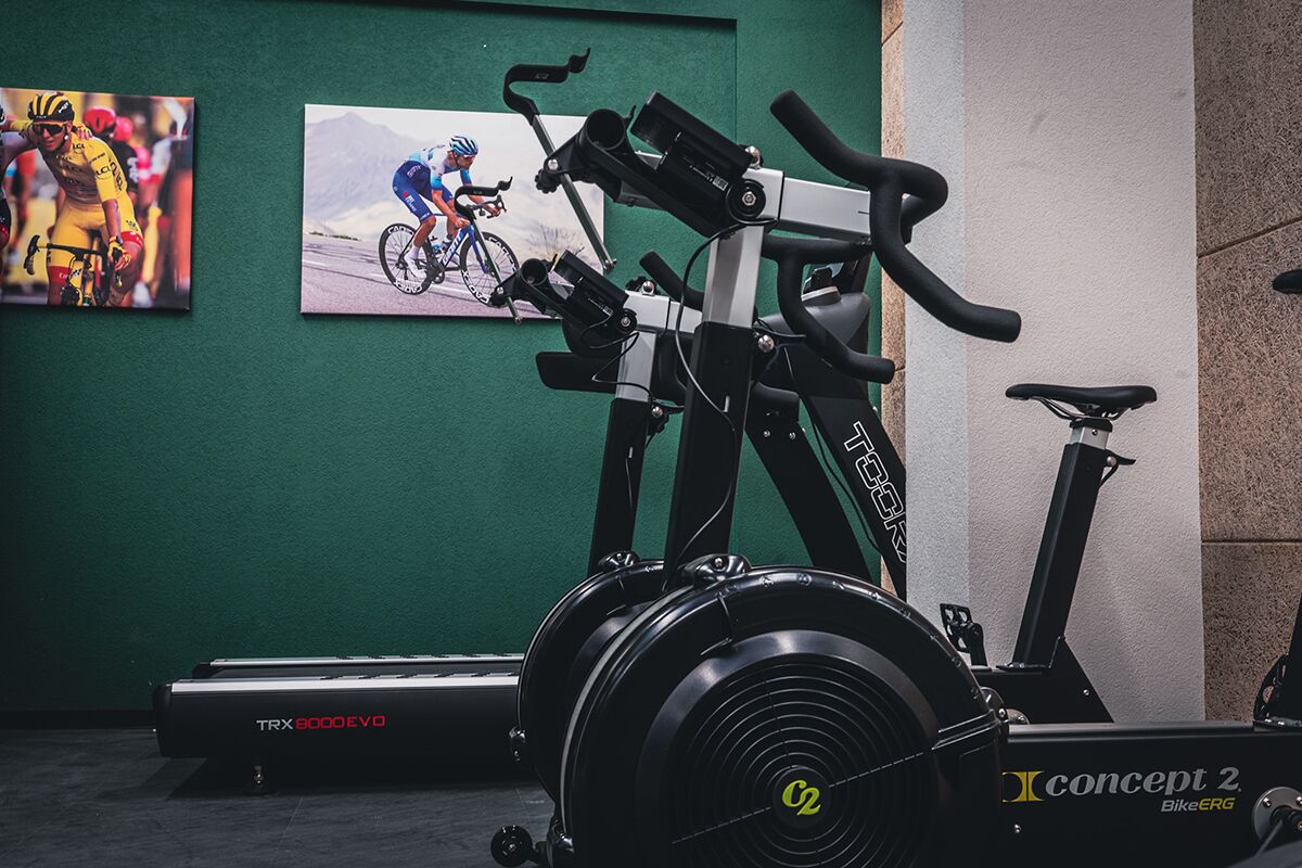 A gym with stationary bikes, a TRX 3000 EVO, and a concept 2 bike ergometer.