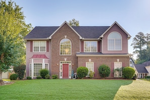 A two-story house with a red door, multiple windows, and a well-maintained lawn. - 4 Mi to Chattahoochee River: Family Home w/ Yard! (Roswell)
