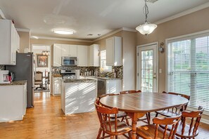 A spacious kitchen with a central island, white cabinetry, and a dining area with wooden chairs. - 4 Mi to Chattahoochee River: Family Home w/ Yard! (Roswell)