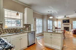 A kitchen with a dishwasher, a dining area with a fireplace, and a living room with a TV. - 4 Mi to Chattahoochee River: Family Home w/ Yard! (Roswell)