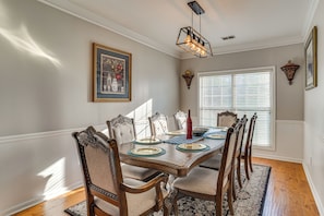 A dining room with a wooden table set for six, surrounded by upholstered chairs with intricate designs. - 4 Mi to Chattahoochee River: Family Home w/ Yard! (Roswell)