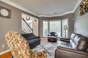 A living room with a patterned armchair, a leather sofa, and a rug. - 4 Mi to Chattahoochee River: Family Home w/ Yard! (Roswell)