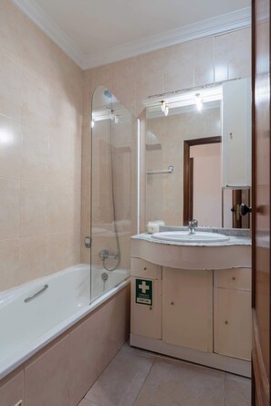 Ein Badezimmer mit Badewanne, Waschbecken und Spiegel.