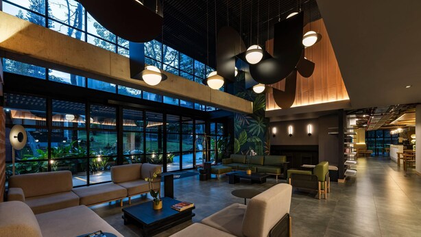 A spacious lobby with seating areas, large windows, and modern lighting fixtures. - Faranda Collection Medellin, a Member of Radisson Individuals (Medellín)