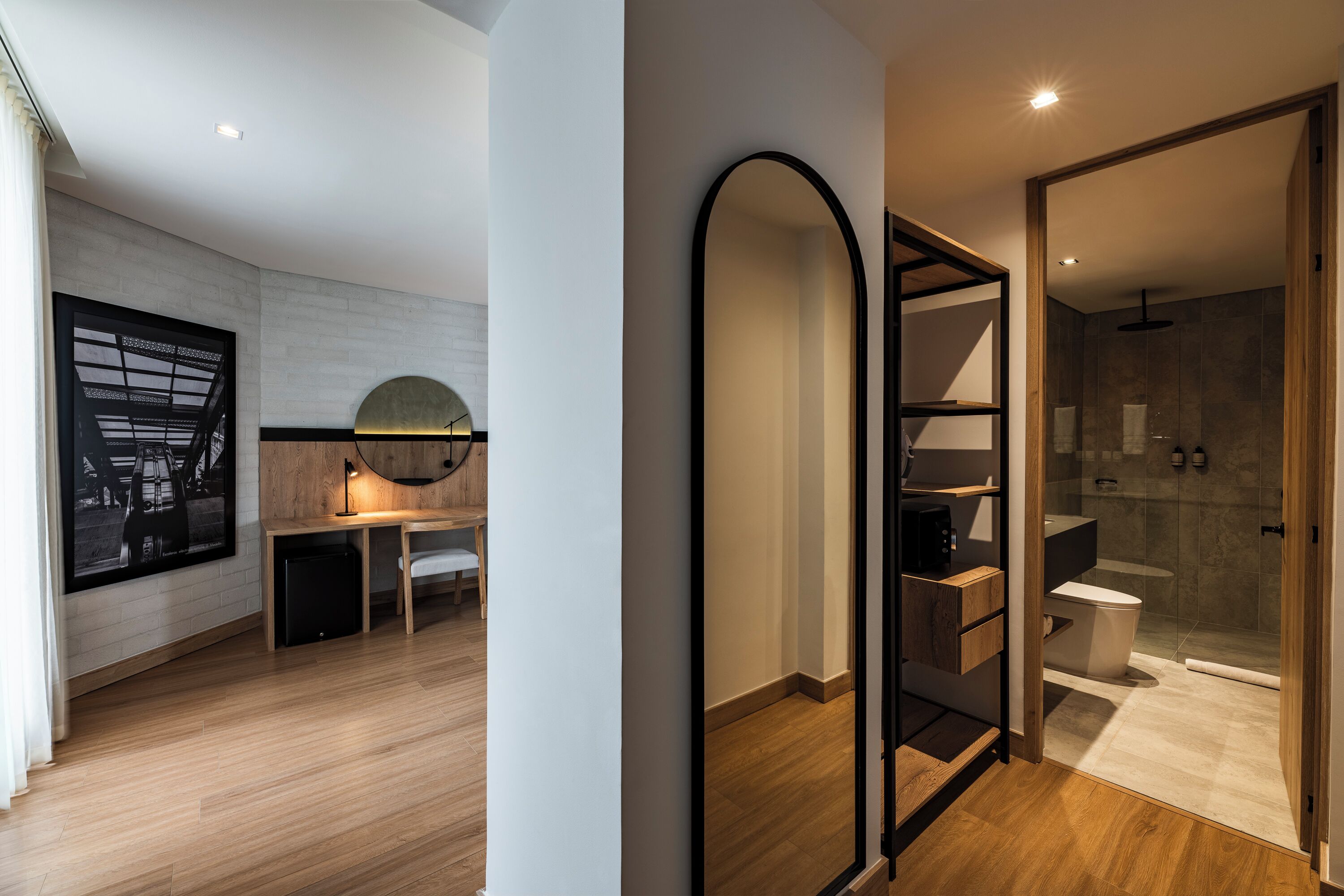 Un baño moderno con cabina de ducha de vidrio, tocador de madera y un espejo grande.