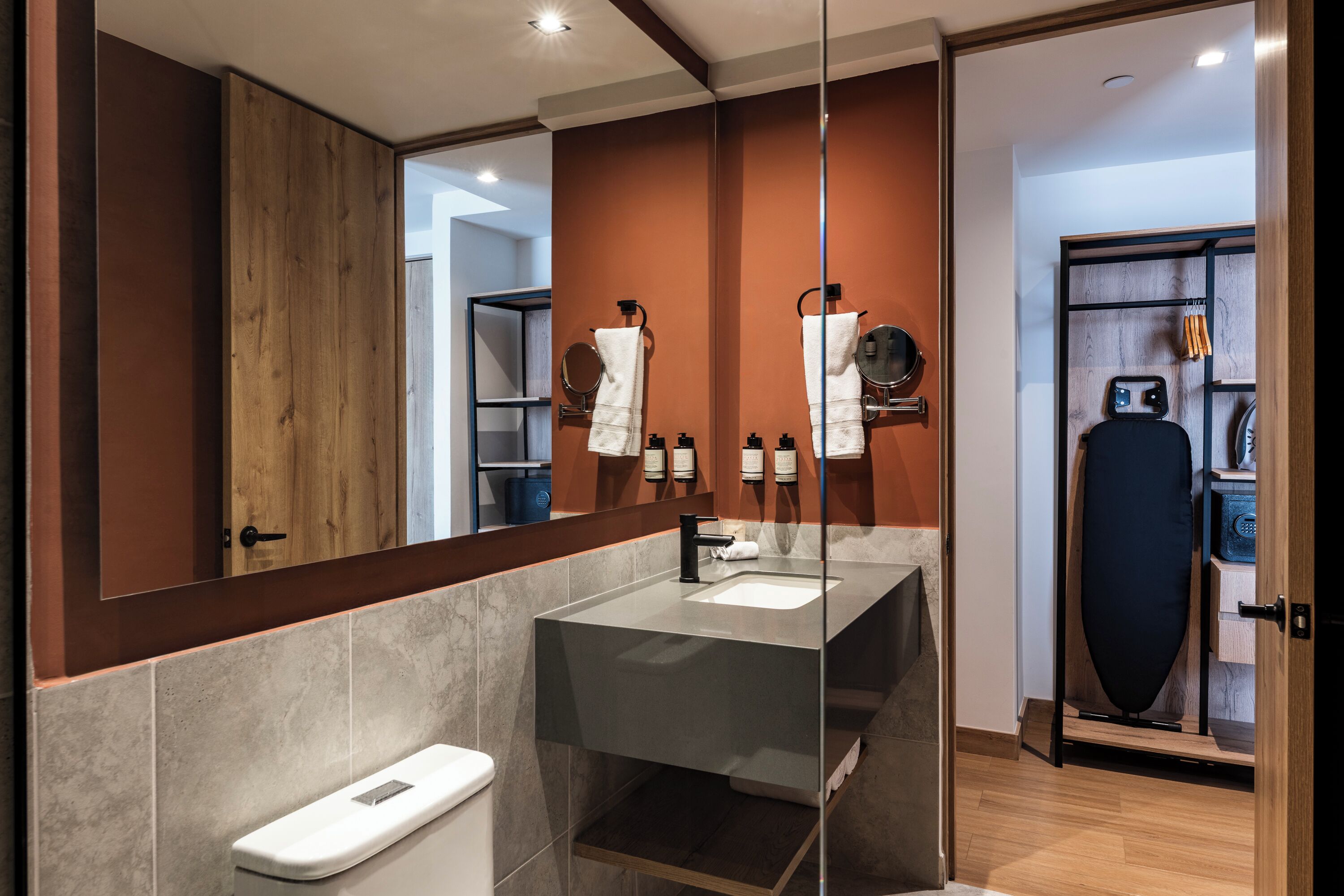A modern bathroom with a large mirror, a sink, and a shower area.