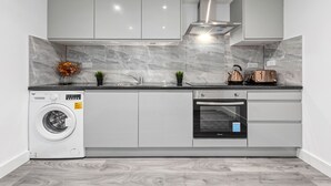 Eine moderne Küche mit integriertem Waschmaschine, Backofen und Toaster.