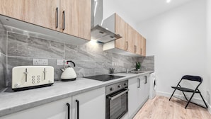 Eine moderne Küche mit ein eingebautem Backofen, einem Toaster und einem Wasserkocher auf der Arbeitsplatte.