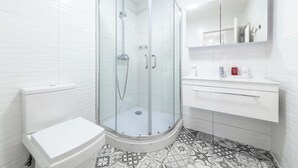 A modern bathroom with a glass-enclosed shower, a toilet, and a vanity with a mirror and shelves. - Stunning Double Bed Room In Isleworth TW7 (Isleworth)