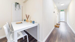 A modern hotel room with a white dining table, chairs, and a small plant decoration. - Stunning Double Bed Room In Isleworth TW7 (Isleworth)