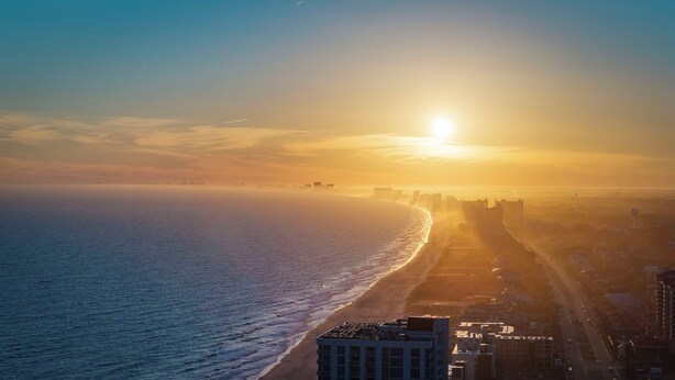 A coastal cityscape with a beach and high-rise buildings during sunset. - 2 blocks 2 beach, Golf Cart, Outdoor Bar, Dogs Welcome, Beach Gear (Atlantic Beach)