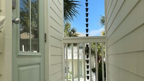 A narrow, white-walled corridor with a door and a small porch area. - Adorable Starlight EscapeCottage (Panama City Beach)
