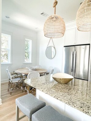 A kitchen with a central island, stainless steel appliances, and a hanging light fixture. - Moonlight and Starlight Escape (Panama City Beach)