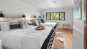 Un dormitorio con dos camas, una ventana y un radiador.