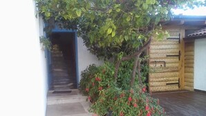 A covered outdoor area with a staircase leading to a building entrance, surrounded by greenery and a tiled floor. - Studio apartment in Sućuraj with Seaview, Balcony, Air condition, WIFI (3560-3) (Sucuraj)