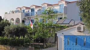 Ein Gebäude mit weißer Fassade, blauen Fensterläden und einer Flagge.