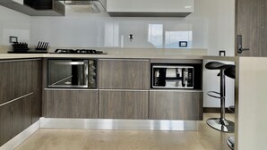 Una cucina moderna con forno integrato, microonde e piano cottura a gas.