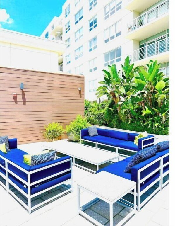 Relax in an outdoor space surrounded by lush greenery and comfortable seating.