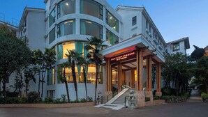 Un hotel moderno con fachada curva, ventanas amplias y una entrada destacada con escaleras.