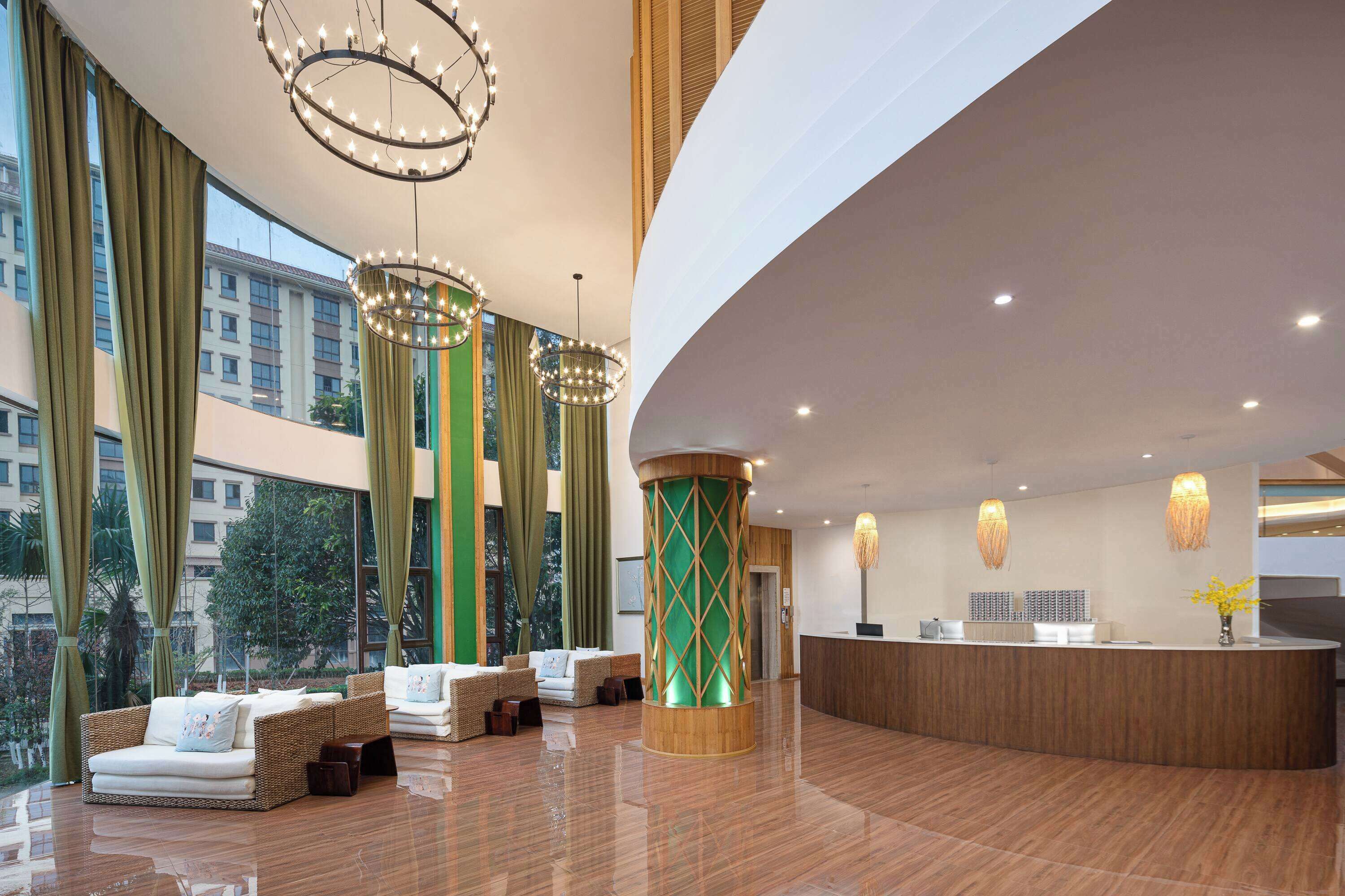Eine großzügige Lobby mit einer Rezeption, bequemen Sitzbereichen und großen Fenstern mit Blick auf die Stadt.
