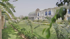 A large building with a symmetrical facade, multiple windows, and a central dome.