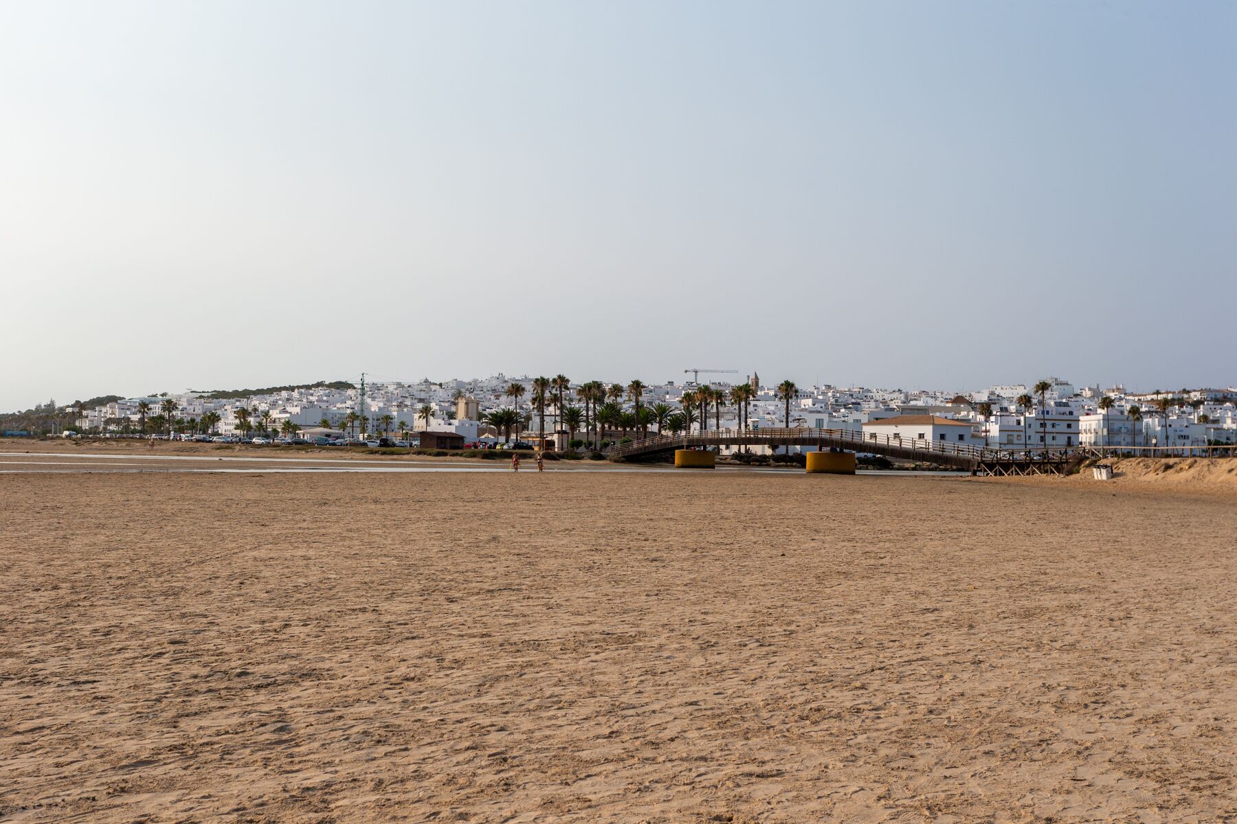 A beach with a cityscape in the background.