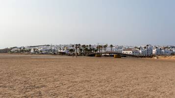 A beach with a cityscape in the background.