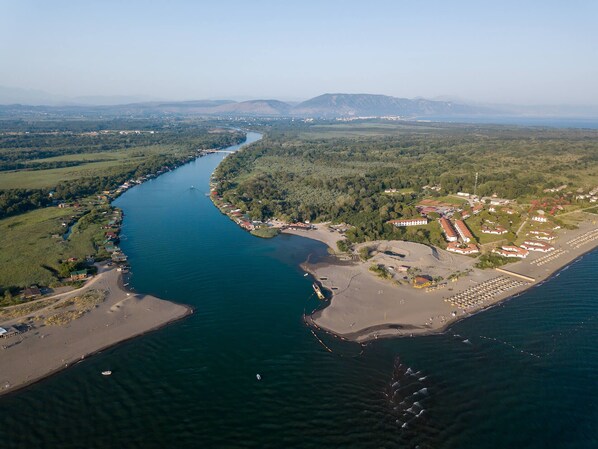 Vista aérea de una zona costera con un río, una playa y edificios residenciales.
