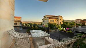 A balcony with wicker furniture and potted plants. - Cappadocia Acer Living Home (Ürgüp)