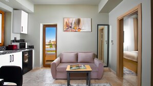 A modern living room with a sofa, a coffee table, and a painting on the wall. - Cappadocia Acer Living Home (Ürgüp)