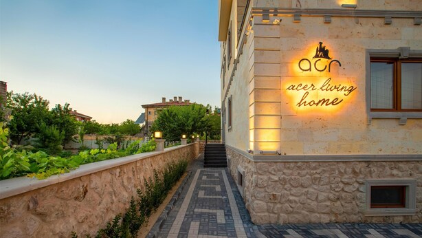 A stone building with a sign reading "Acer Living Home" and a paved pathway leading to a staircase. - Cappadocia Acer Living Home (Ürgüp)
