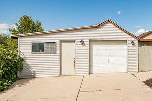 Stylish single-story home with a gabled roof and symmetrical facade, featuring two garage doors and a small window.