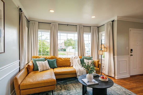Relax in this inviting living room with a comfortable sofa, coffee table, and natural views.