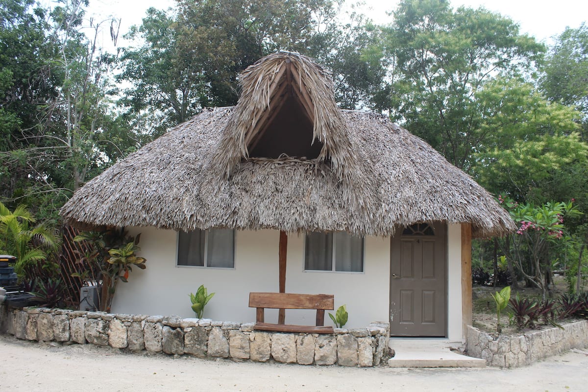 A small building with a thatched roof and a wooden bench in front.