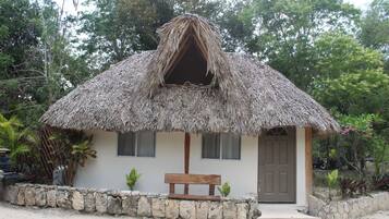 A small building with a thatched roof and a wooden bench in front.