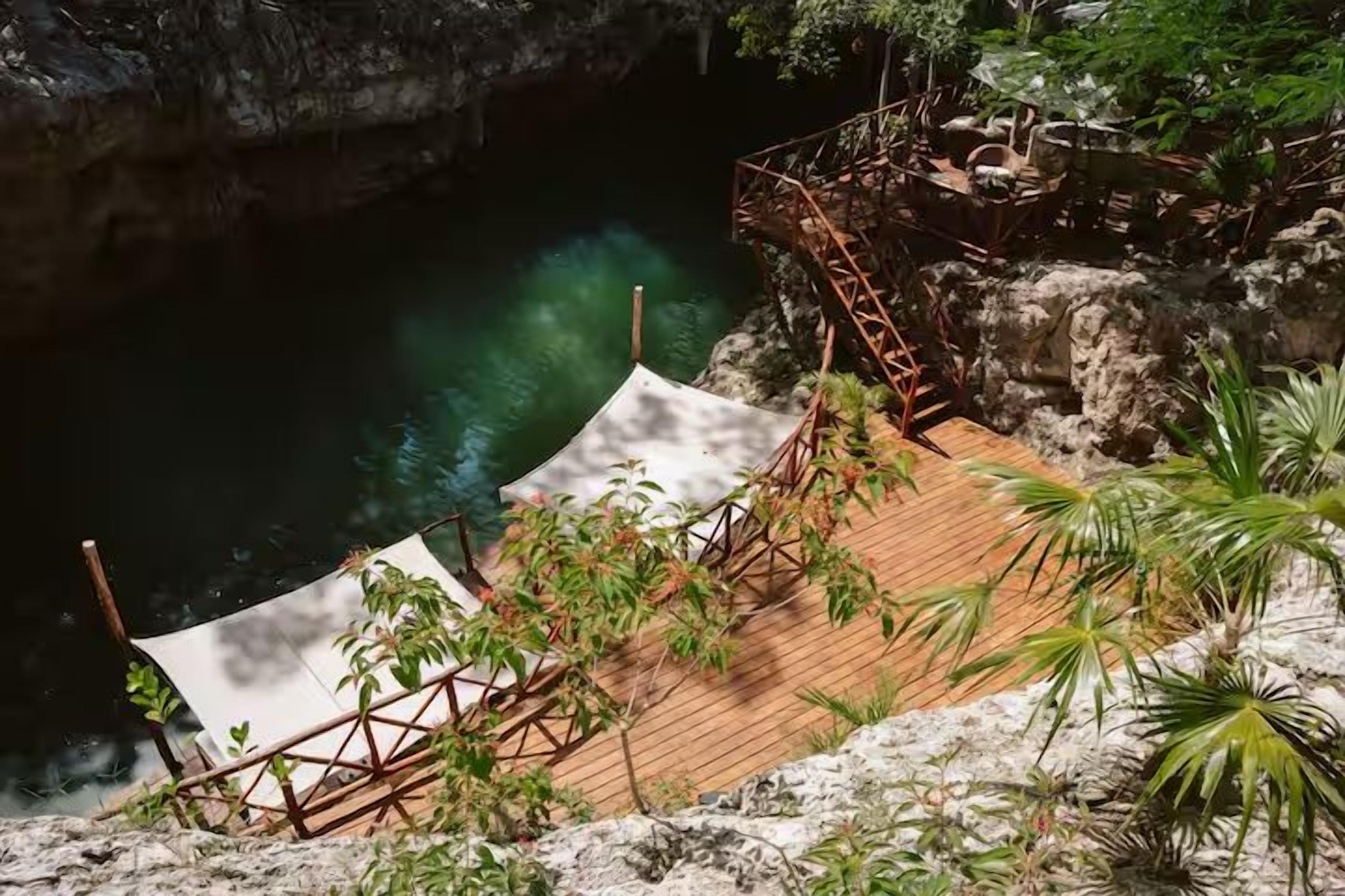 A wooden deck with a metal railing overlooking a body of water.