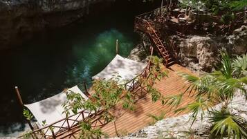 A wooden deck with a metal railing overlooking a body of water.