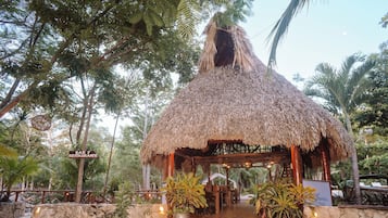 Una estructura con techo de paja y un letrero que indica un restaurante.