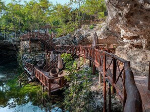 A wooden bridge over a rocky cliff with a view of a natural landscape. - Ka'ax Cenote Resort (Akumal)