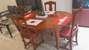 A dining area with a round wooden table, four chairs, and a small potted plant. - Location Maison 3 Chambres Circuit des 24H (Le Mans)