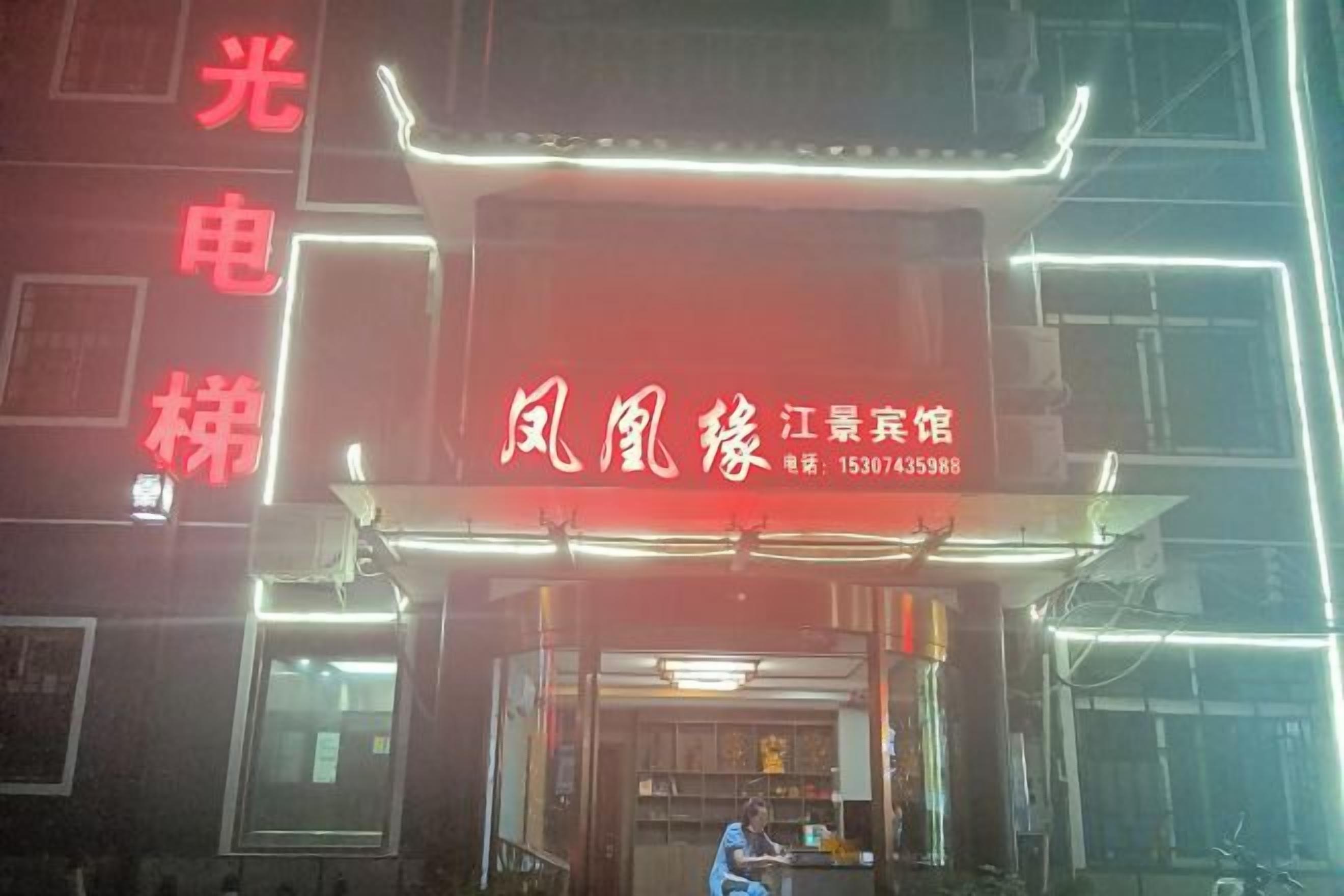 Ein Gebäude mit einer Neonreklame und einer Schaufensterfront.