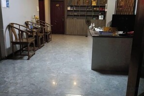 Un pasillo con una zona de estar con banca de madera, una encimera de cocina y una puerta que da a otra habitación.