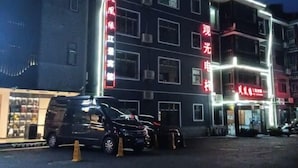 Un edificio de varios pisos con letreros iluminados en rojo y blanco.