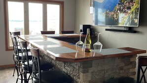 Una cocina moderna con una isla grande, taburetes de bar y un televisor de pantalla plana montado en la pared.