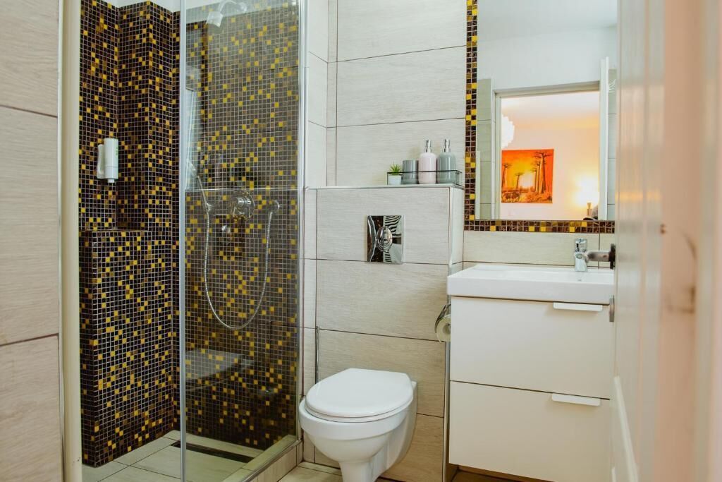 A bathroom with a shower, toilet, and sink.
