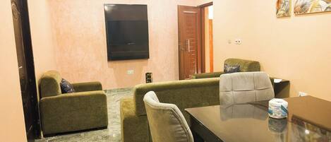 Una habitación con un sofá, una mesa y una puerta.