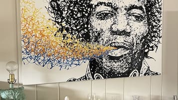 A wall-mounted artwork with a black and white abstract design and colorful splashes at the bottom.