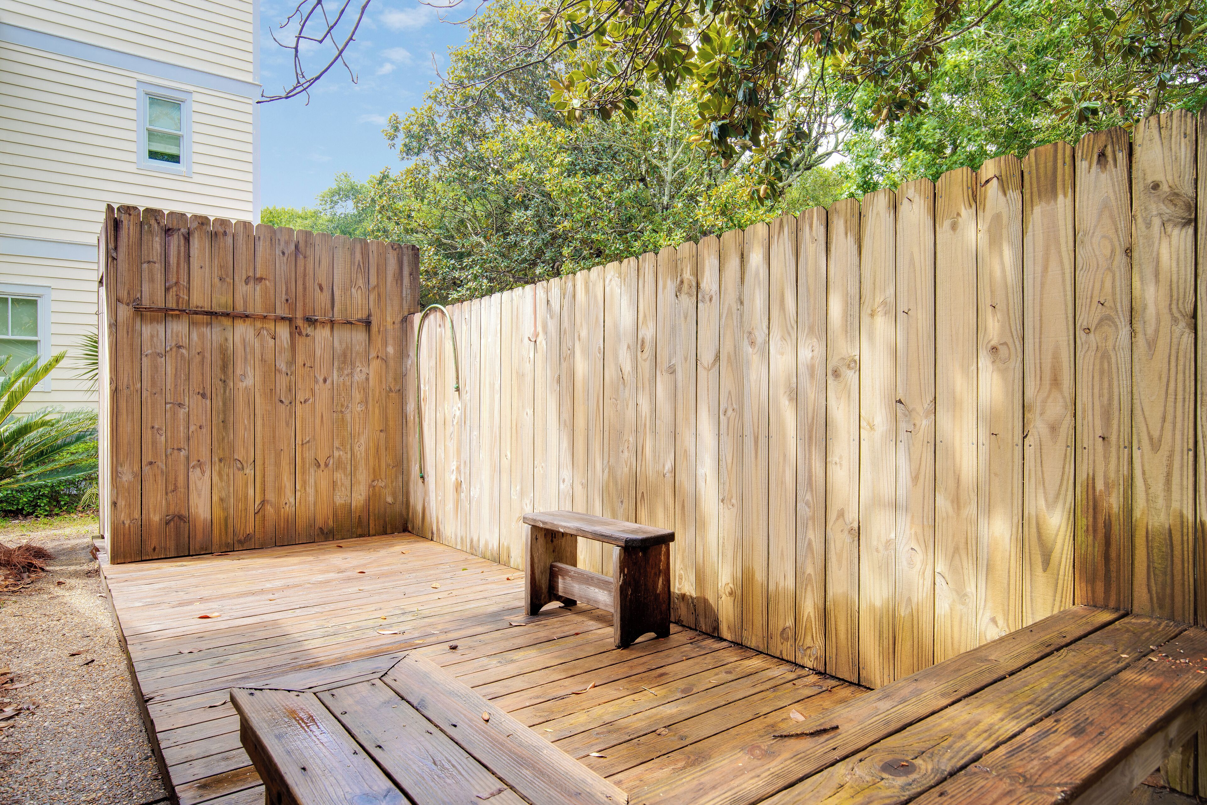 A wooden deck with a bench and a wooden fence.